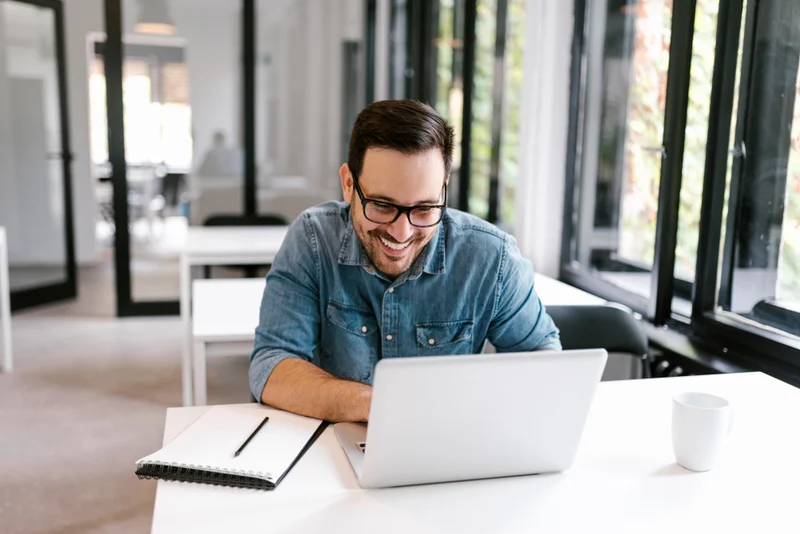 cheerful businessman using laptop